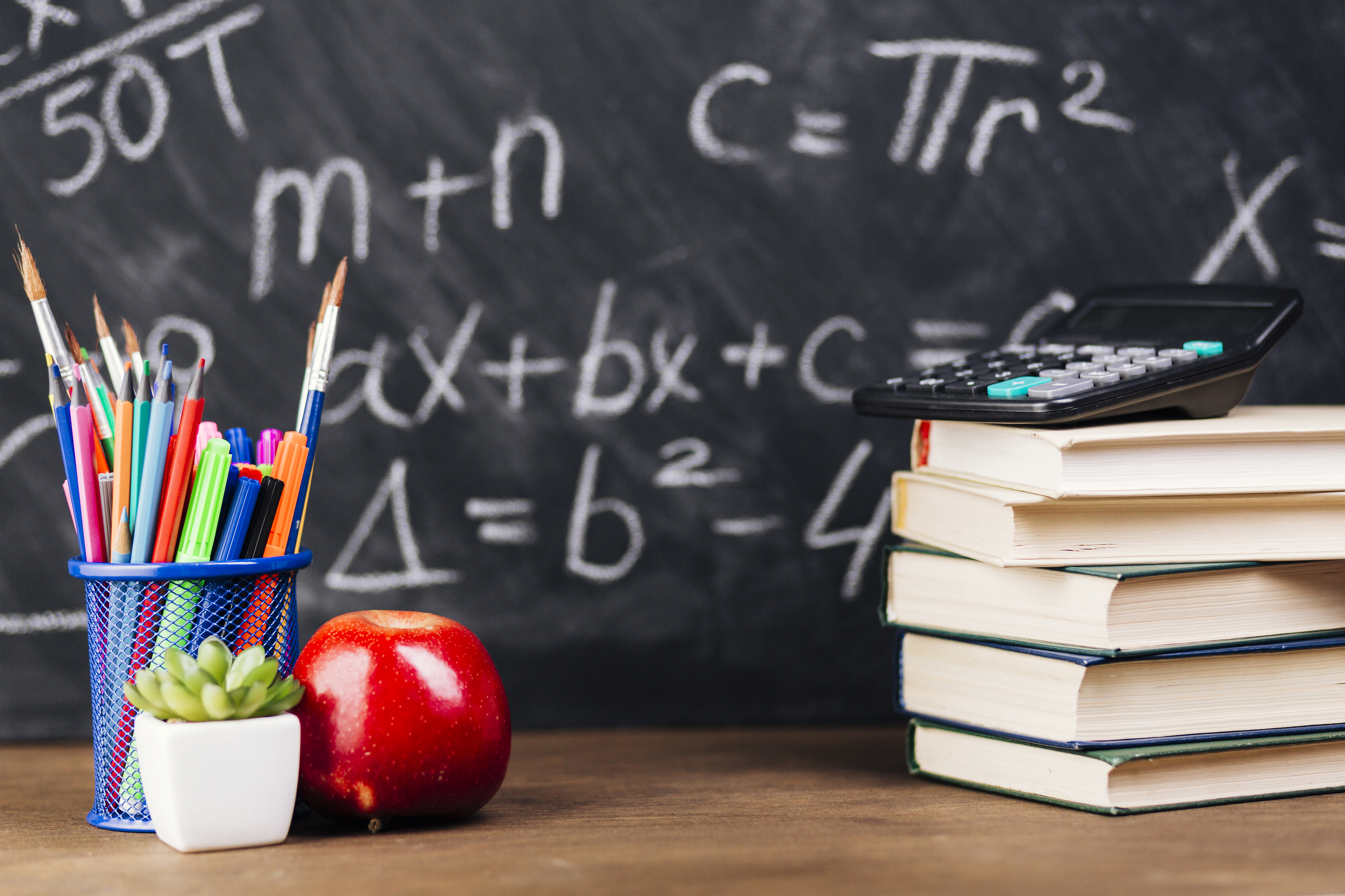 stationery-stacked-books-placed-desk-chalkboard-background